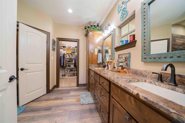 4754 Deer Rd, Gilmer, TX 75644 - full bathroom with a walk in closet, double vanity, wood finished floors, and a sink