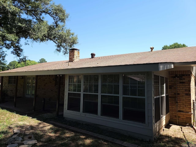 711 Wildwood Rd, Daingerfield, TX 75638 - back of house with brick siding, a chimney, a patio, and a shingled roof