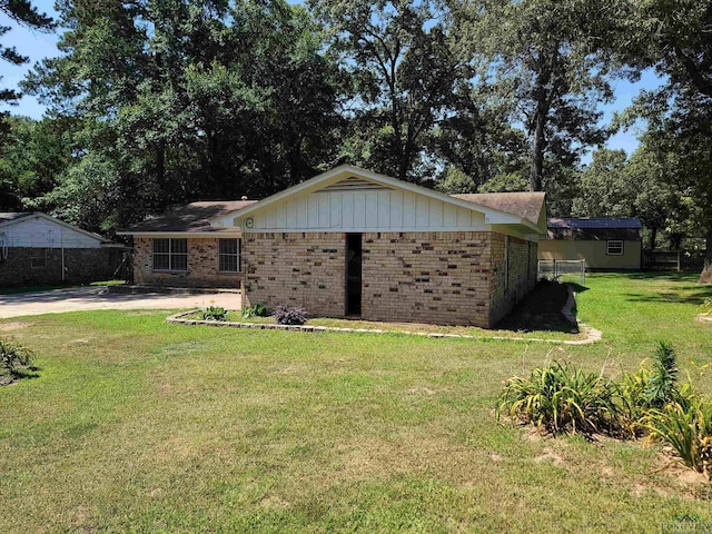 711 Wildwood Rd, Daingerfield, TX 75638 - view of front of house with brick siding, board and batten siding, and view of wooded area