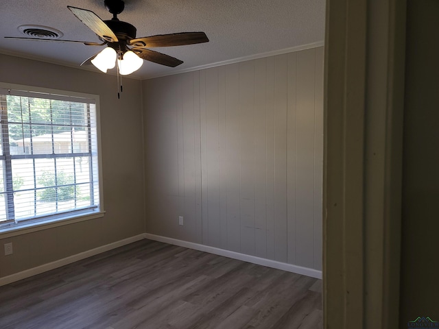 711 Wildwood Rd, Daingerfield, TX 75638 - empty room featuring plenty of natural light, a textured ceiling, crown molding, dark wood finished floors, and ceiling fan