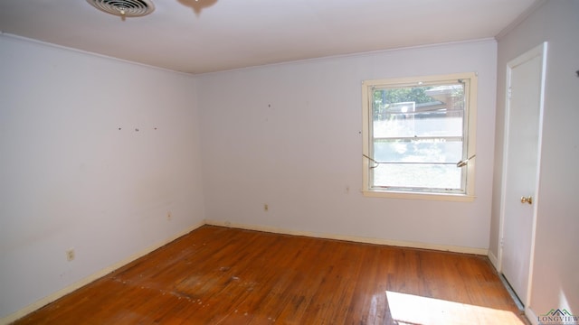 unfurnished room featuring hardwood / wood-style floors and crown molding