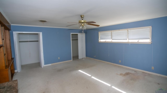 unfurnished bedroom with ceiling fan, carpet floors, and two closets