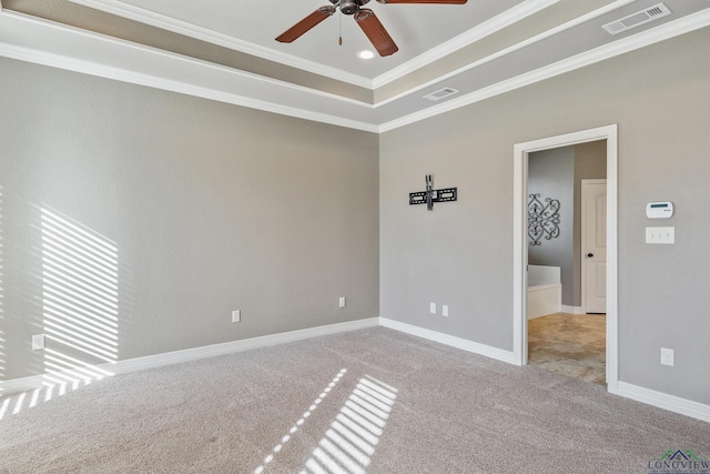 carpeted spare room featuring ceiling fan, ornamental molding, and a tray ceiling