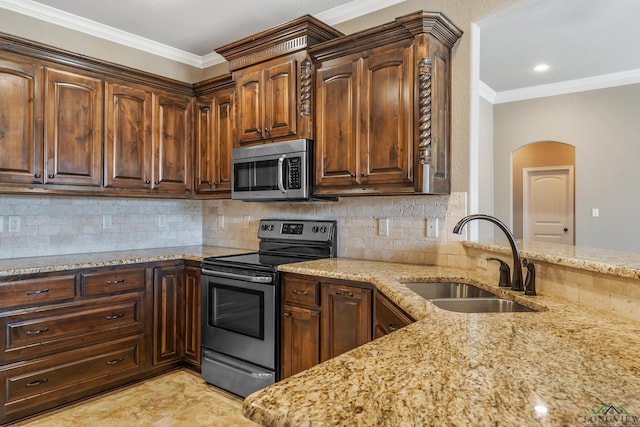 kitchen with stainless steel appliances, crown molding, light stone counters, and sink