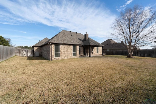 rear view of property featuring a lawn