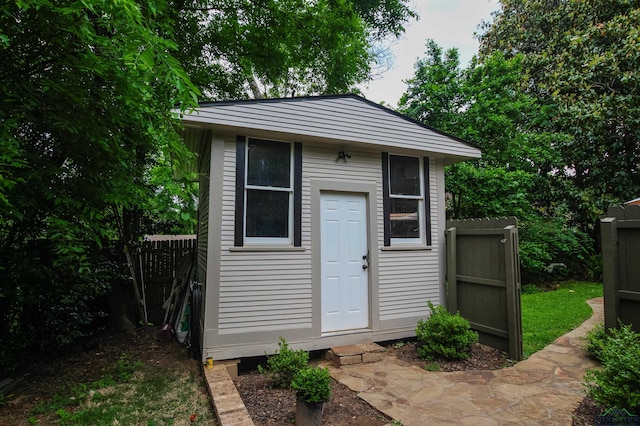 view of outbuilding featuring fence and an outbuilding