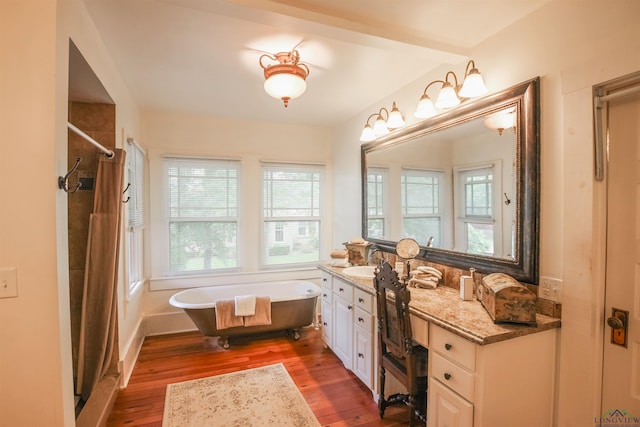 full bathroom featuring wood finished floors, vanity, a stall shower, and a soaking tub