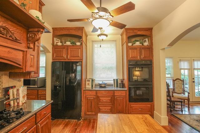 kitchen featuring a ceiling fan, arched walkways, open shelves, and black appliances