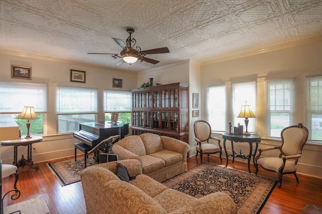 living room with ornamental molding, wood-type flooring, and a ceiling fan