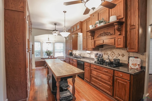 kitchen featuring butcher block countertops, light wood-style floors, ceiling fan, backsplash, and dishwasher