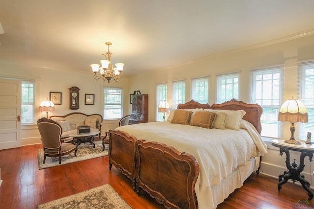 bedroom featuring an inviting chandelier, ornamental molding, dark wood finished floors, and multiple windows