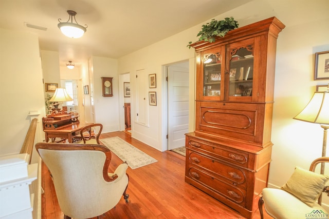 living area featuring visible vents and wood finished floors