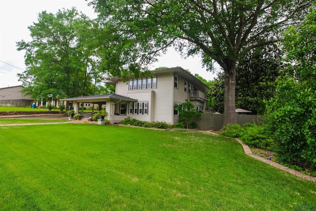 rear view of house featuring a yard and fence