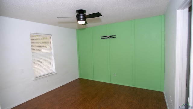 unfurnished room featuring ceiling fan, dark hardwood / wood-style flooring, and a textured ceiling