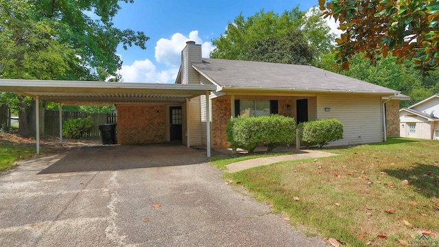 ranch-style home featuring a carport and a front lawn