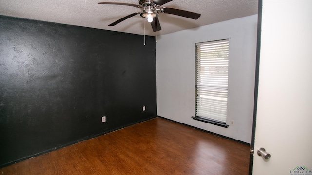 unfurnished room featuring dark hardwood / wood-style floors, ceiling fan, and a textured ceiling