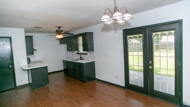 kitchen featuring sink, dark wood-type flooring, pendant lighting, a textured ceiling, and ceiling fan with notable chandelier