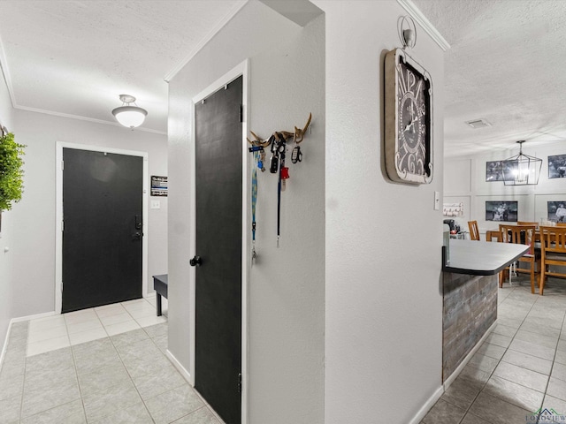 corridor featuring crown molding, light tile patterned floors, and a textured ceiling