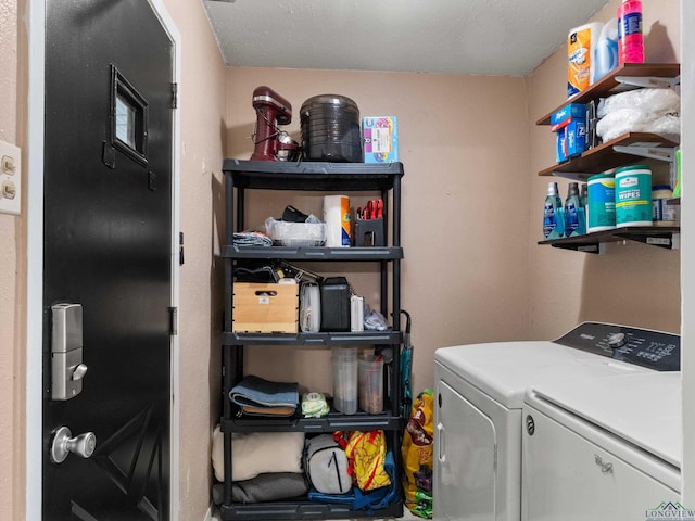 clothes washing area with washing machine and clothes dryer and a textured ceiling