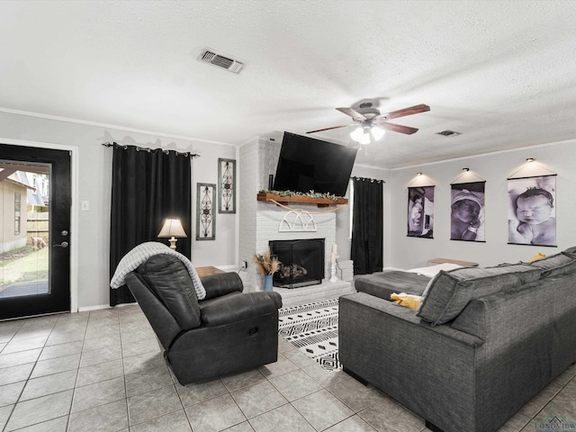 living room with crown molding, light tile patterned floors, a textured ceiling, and a brick fireplace