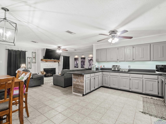 kitchen featuring a fireplace, a textured ceiling, crown molding, and gray cabinetry