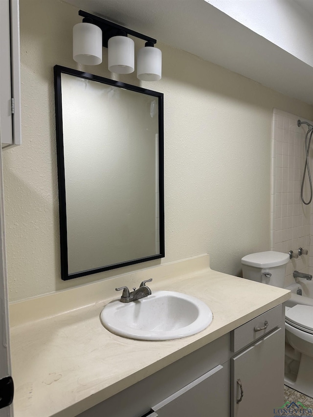 full bathroom with tiled shower / bath combo, vanity, and toilet