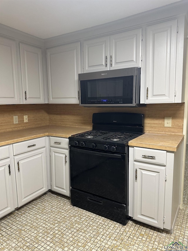 kitchen with tasteful backsplash, white cabinetry, and black gas range oven