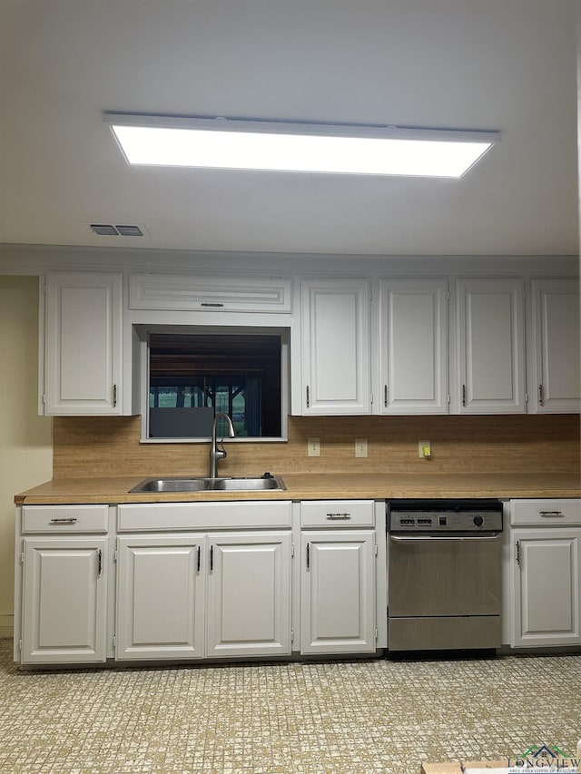 kitchen featuring tasteful backsplash, dishwasher, sink, and white cabinets