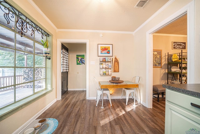 dining area featuring ornamental molding, dark hardwood / wood-style flooring, and a textured ceiling