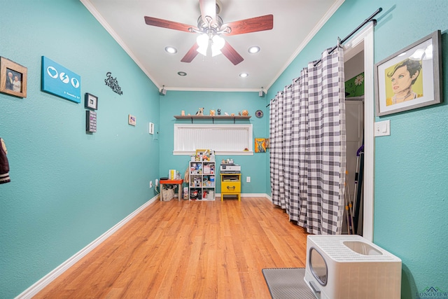 game room with ornamental molding, ceiling fan, and light hardwood / wood-style flooring