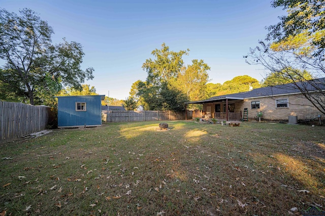 view of yard featuring a fire pit and a storage shed