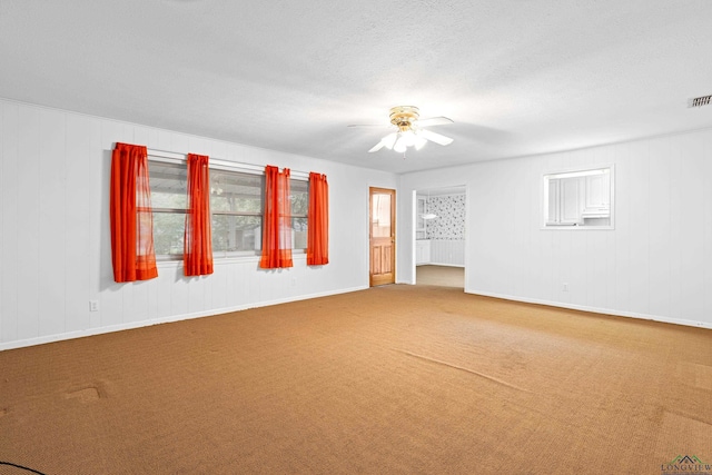carpeted spare room with baseboards and a ceiling fan