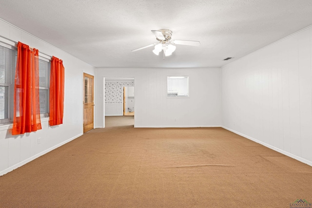 carpeted spare room featuring ceiling fan and baseboards