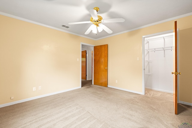 unfurnished bedroom featuring ornamental molding, carpet floors, baseboards, a closet, and a ceiling fan