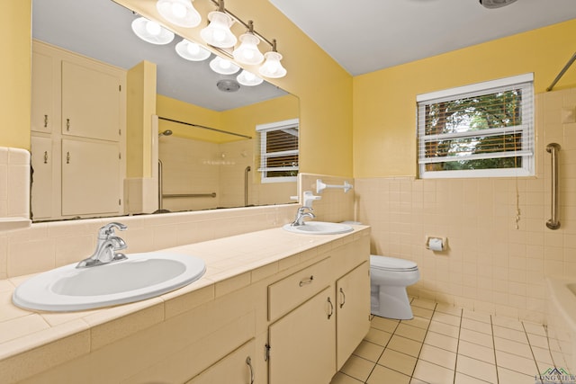 full bath with tile patterned floors, toilet, tile walls, double vanity, and  shower combination