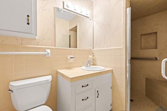 full bath featuring tile walls, a stall shower, wallpapered walls, vanity, and toilet