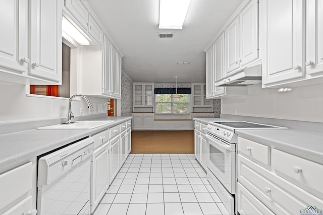 kitchen with white appliances, a sink, light carpet, white cabinets, and light countertops