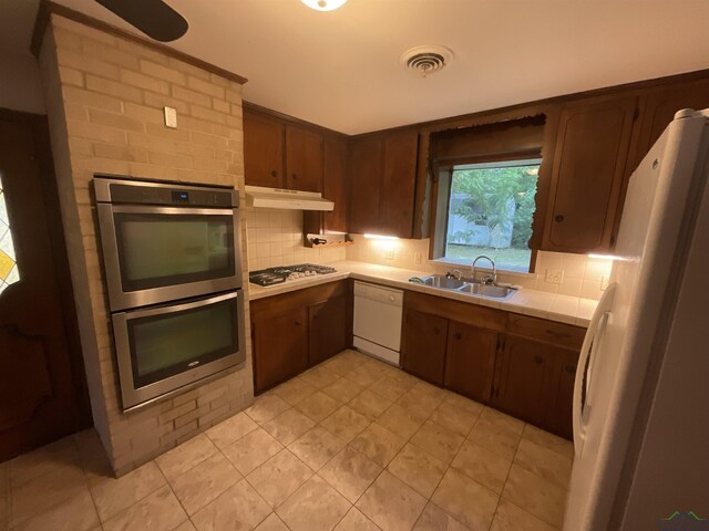402 Mark Dr, Marshall, TX 75672 - kitchen featuring dark brown cabinetry, decorative backsplash, sink, and appliances with stainless steel finishes