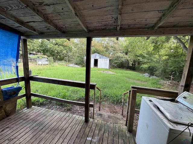 wooden terrace with a shed and a yard