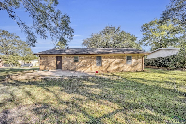 back of property with a yard and a patio