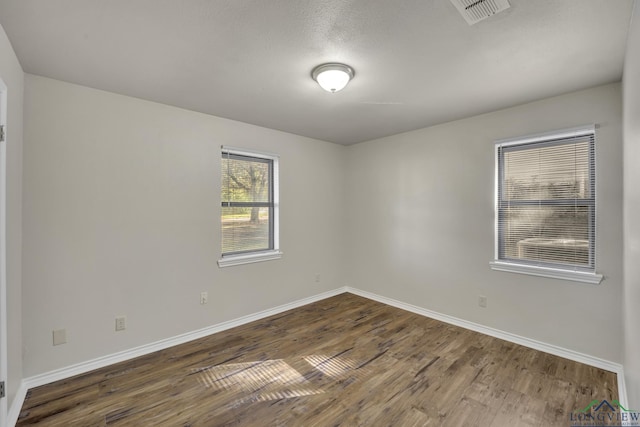 spare room with dark wood-type flooring