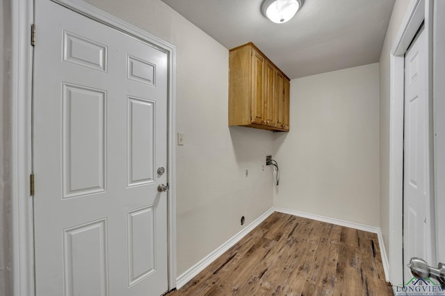 clothes washing area featuring washer hookup, hardwood / wood-style floors, and cabinets