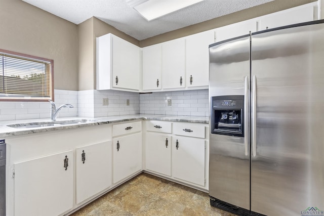 kitchen featuring white cabinets, stainless steel fridge with ice dispenser, and light stone countertops