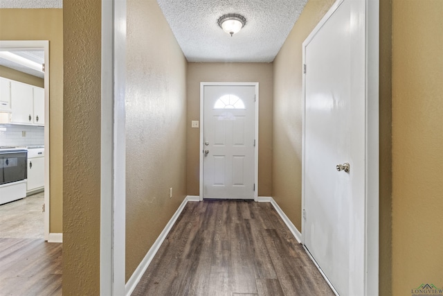 doorway with wood-type flooring and a textured ceiling