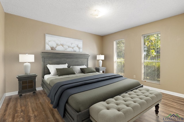 bedroom with dark hardwood / wood-style flooring and a textured ceiling