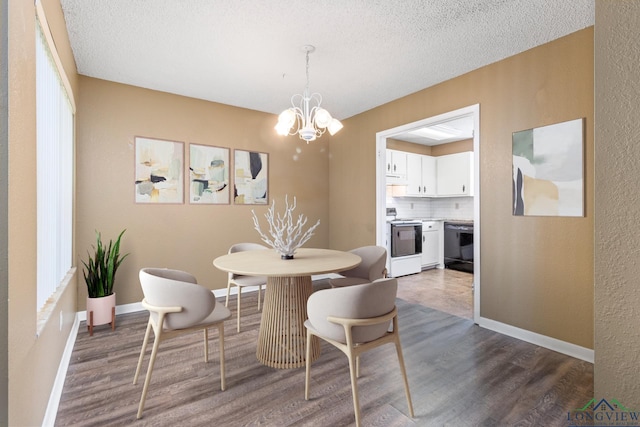 dining area with a textured ceiling, hardwood / wood-style flooring, and an inviting chandelier