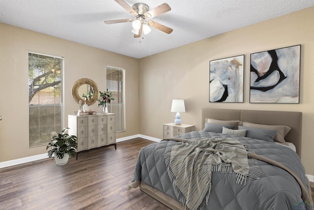 bedroom with ceiling fan, a textured ceiling, and dark wood-type flooring