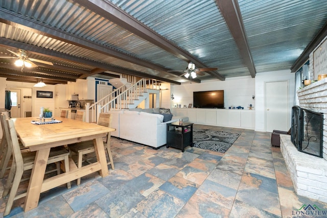 901 N Whatley Rd, White, TX 75693 - living room featuring a ceiling fan, a brick fireplace, stairway, beam ceiling, and stone finish flooring
