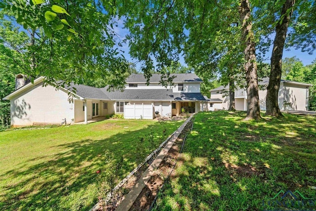 back of property with a lawn and fence