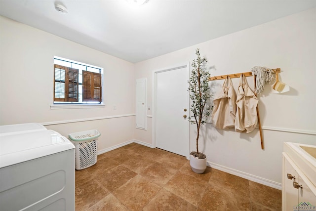 clothes washing area featuring washer and dryer and baseboards